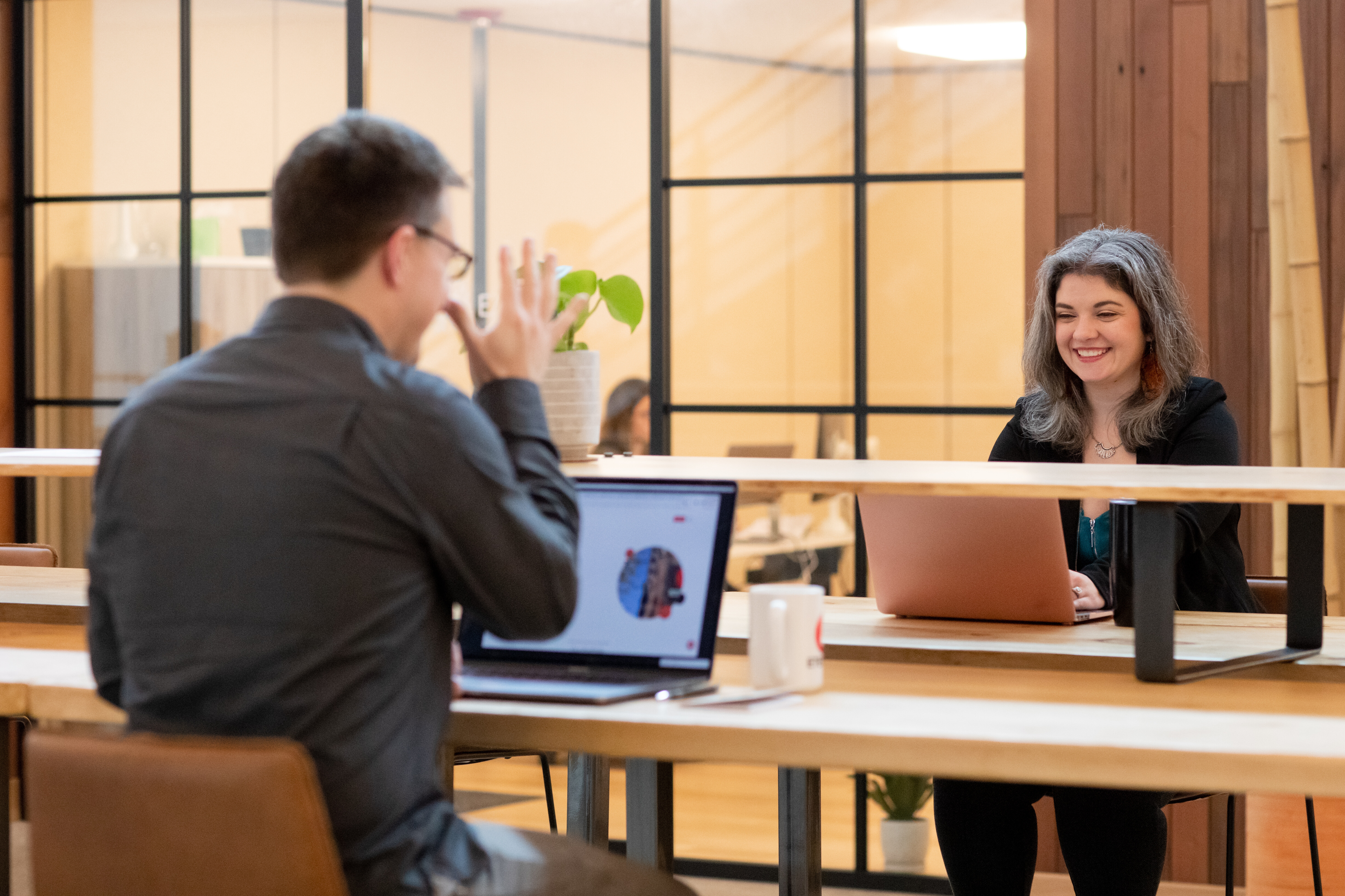 Two colleagues engage in a friendly conversation at a modern workspace.