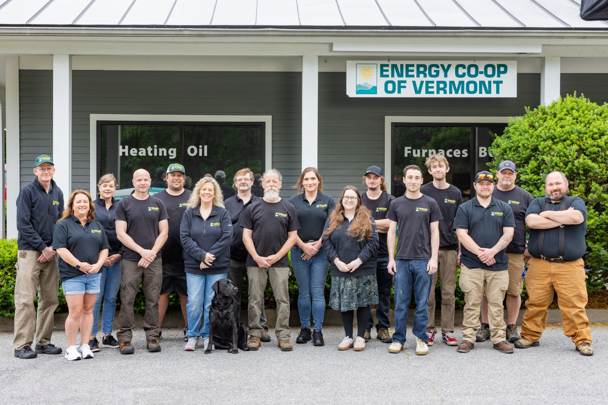 Group of Energy Co-op of Vermont staff, including a dog, posing in front of their building.
