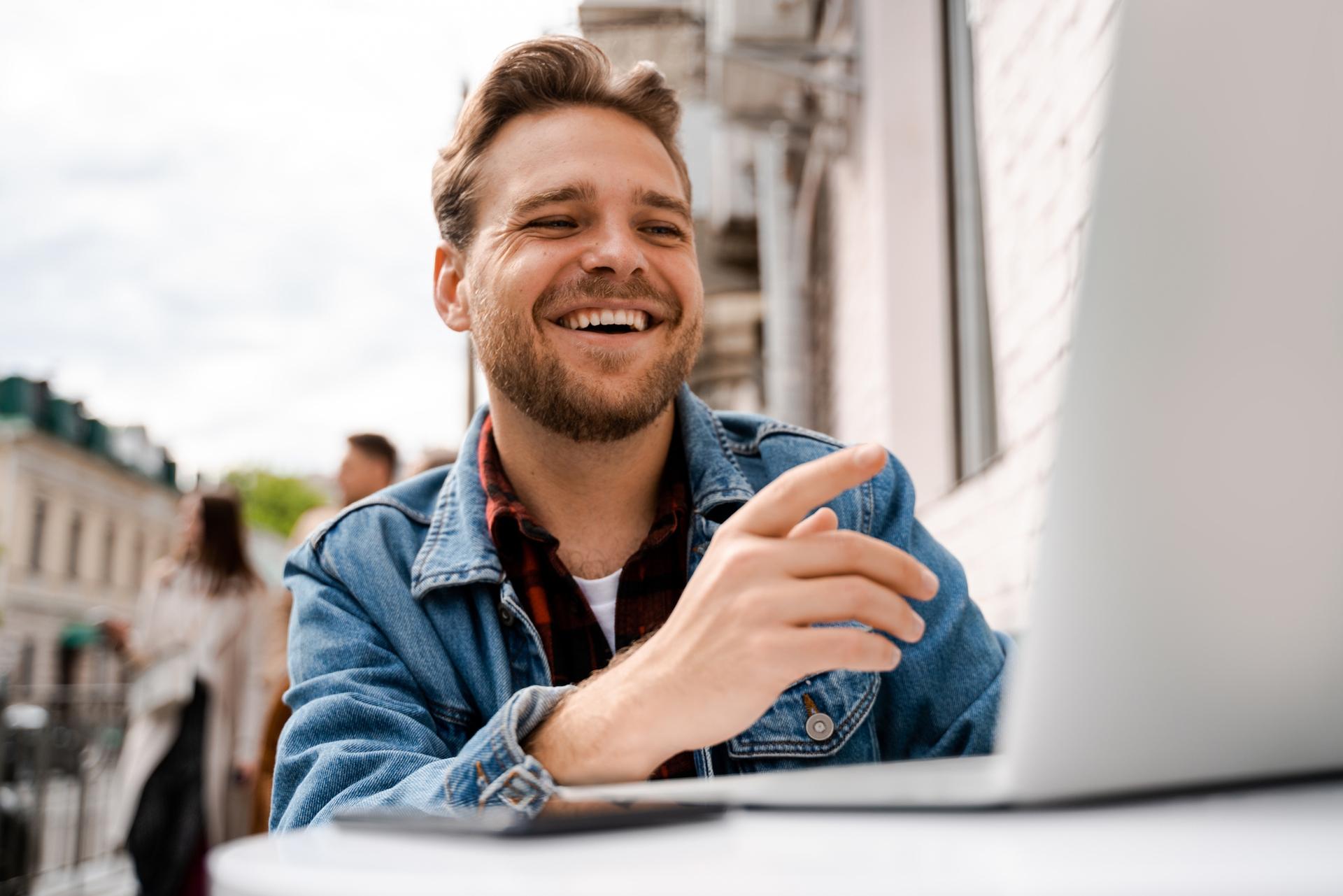 man laughing and pointing at his computer