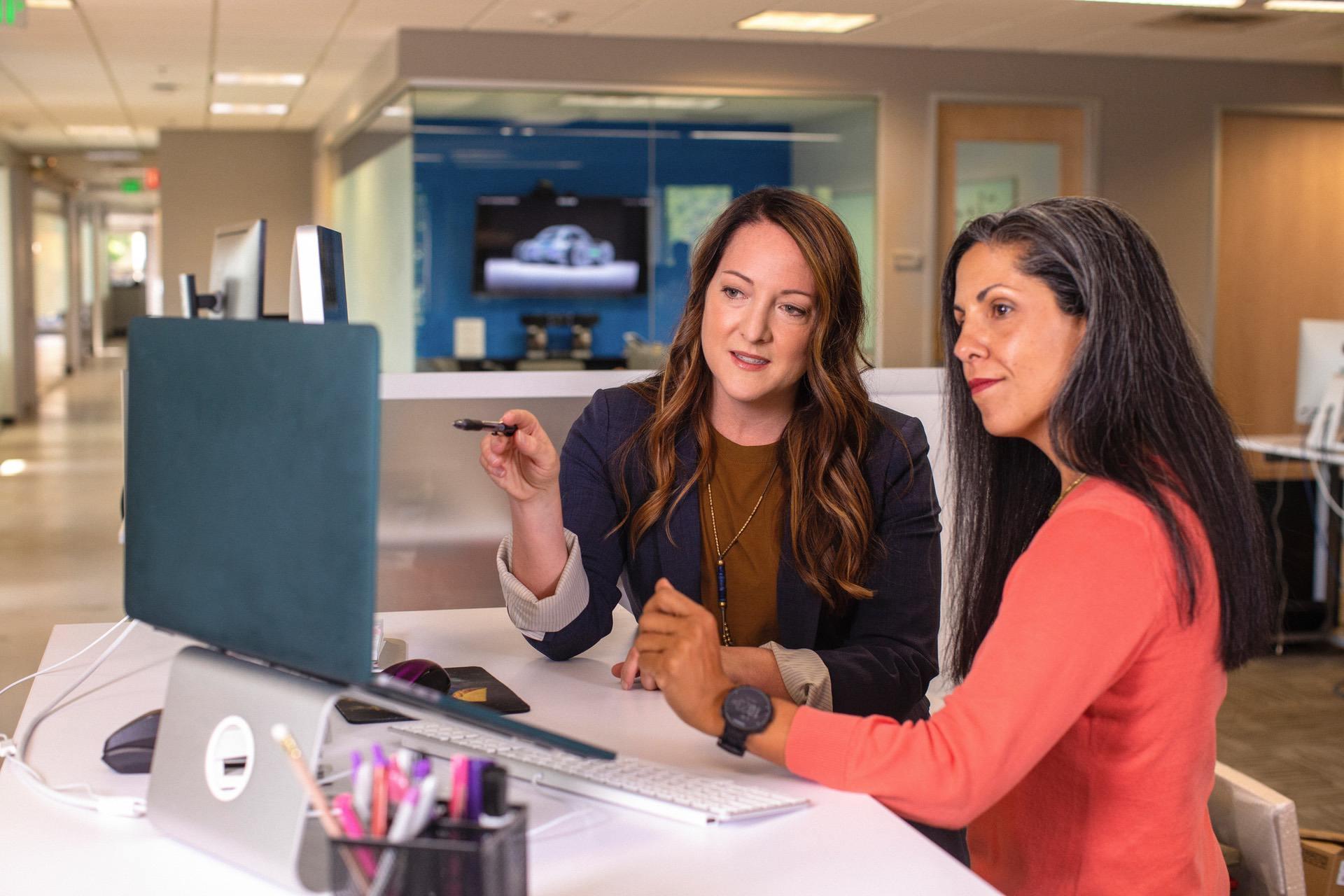 Two women having a meeting at a desk discussing their small business
