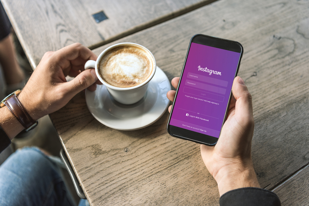 Person holding mobile phone with Instagram on screen