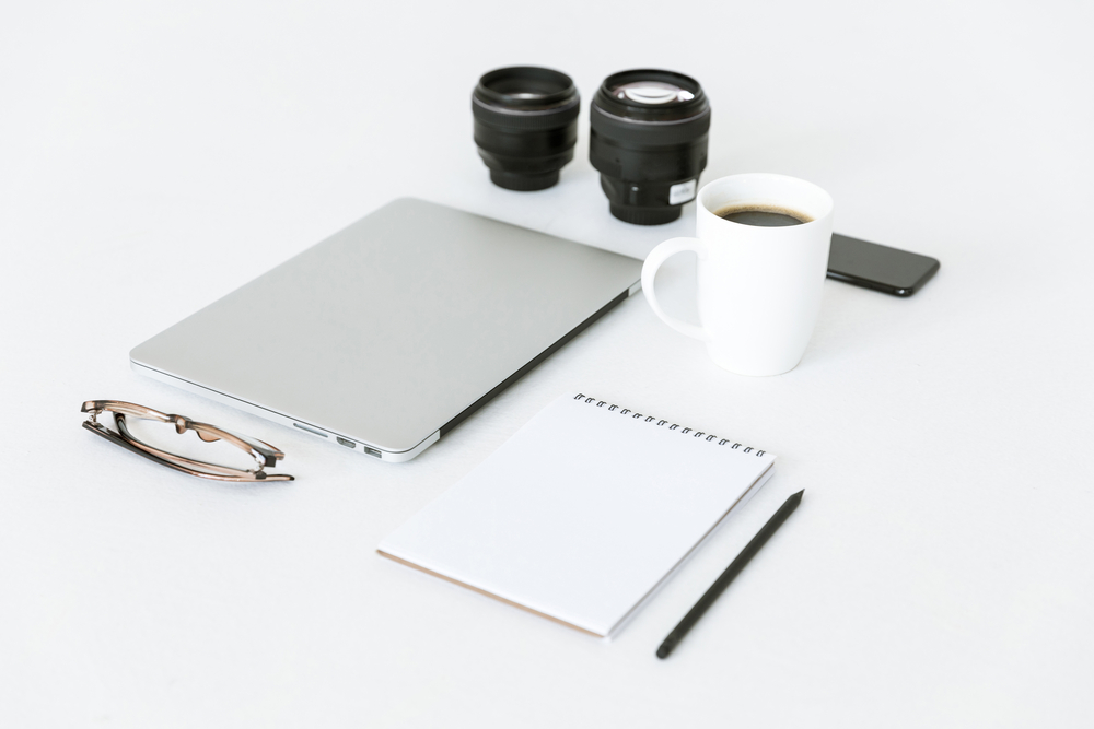 Laptop, Camera, and Mobile Phone sitting on table.